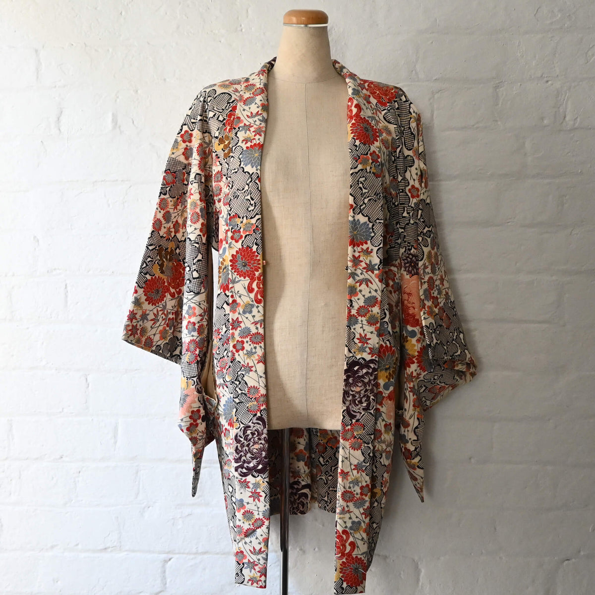 Vintage women's ivory silk crepe haori with an all-over multicoloured Japanese floral pattern.
