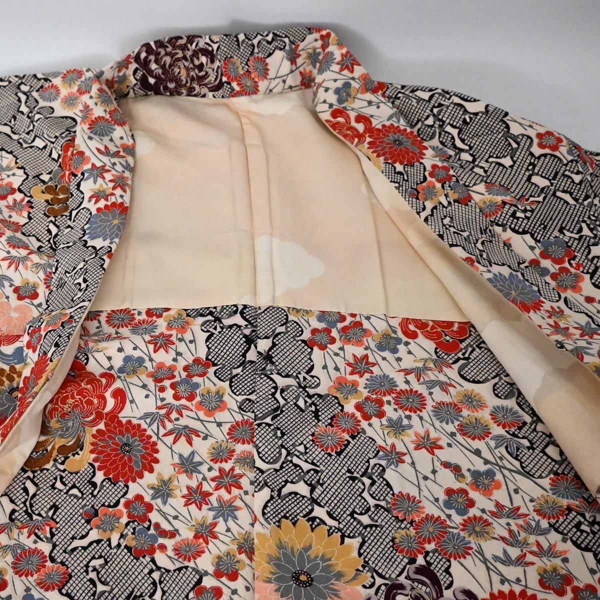 Vintage women's ivory silk crepe haori with an all-over multicoloured Japanese floral pattern.
