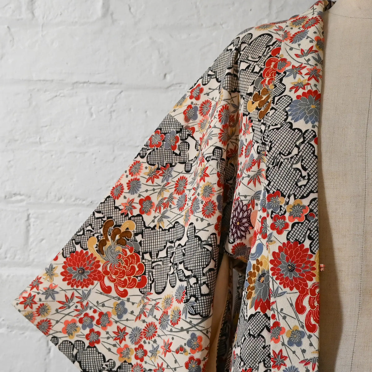 Vintage women's ivory silk crepe haori with an all-over multicoloured Japanese floral pattern.
