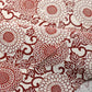 Close-up view of vintage Japanese silk crepe kimono fabric with chrysanthemum arabesque motif in burgundy red.