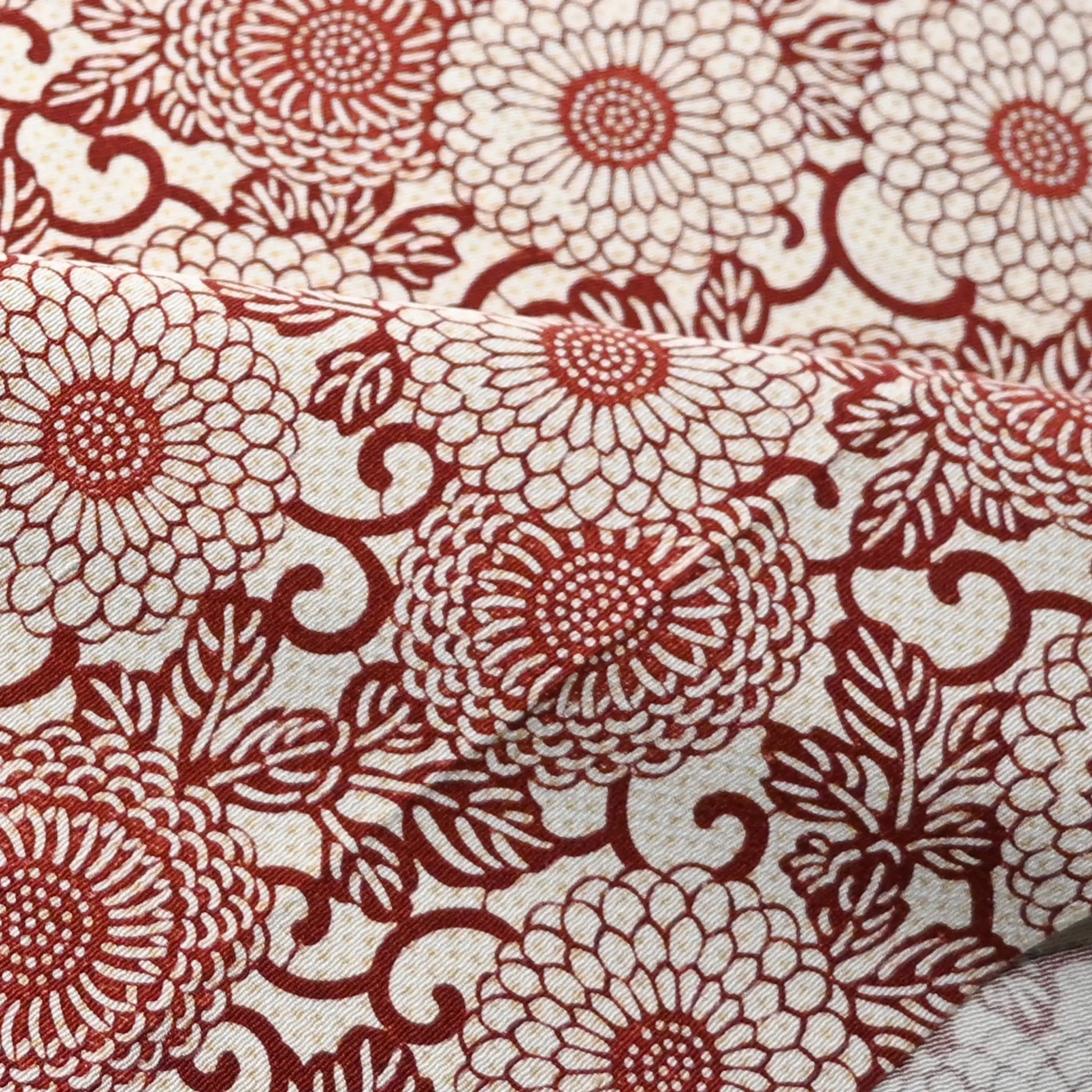 Close-up view of vintage Japanese silk crepe kimono fabric with chrysanthemum arabesque motif in burgundy red.