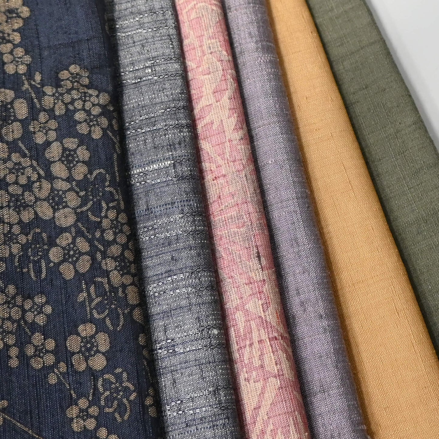 Close-up view of set of six vintage tsumugi silk kimono fabric pieces in softly muted tones, ideal for any craft project.