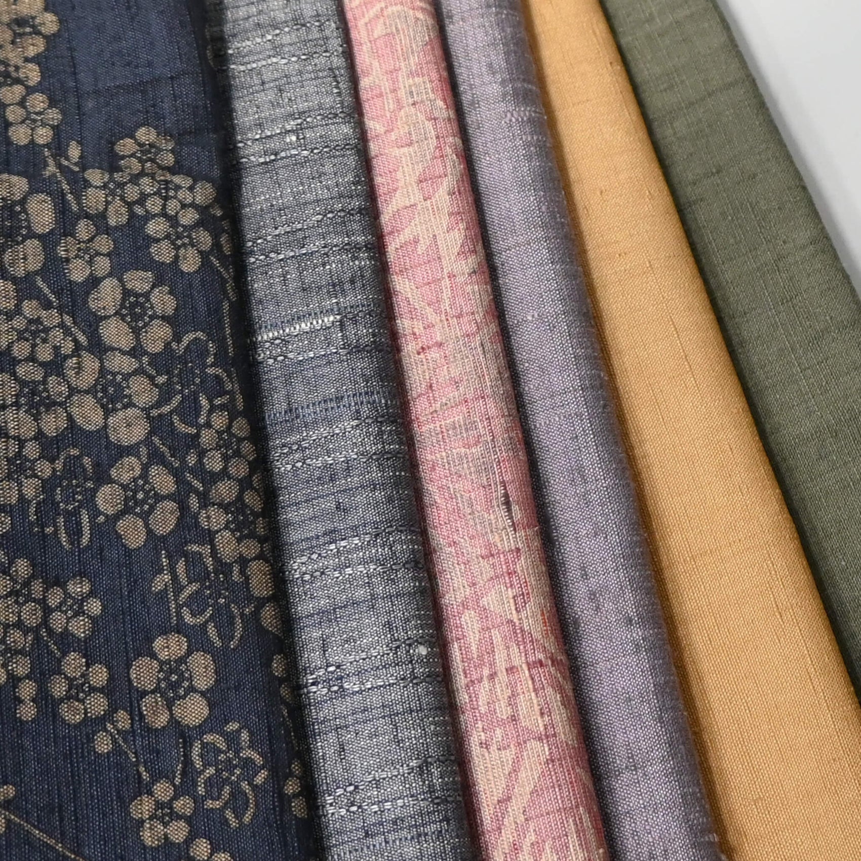 Close-up view of set of six vintage tsumugi silk kimono fabric pieces in softly muted tones, ideal for any craft project.