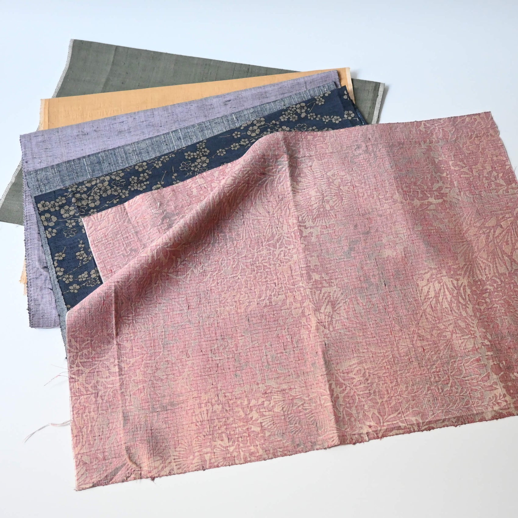 Full view of set of six vintage tsumugi silk kimono fabric pieces in softly muted tones, ideal for any craft project.