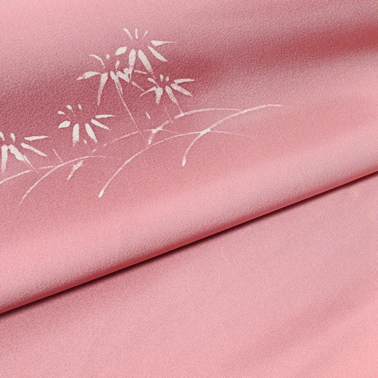 Close-up view of vintage Japanese silk kimono fabric in pale purple with a pink tone, featuring a bamboo motif.