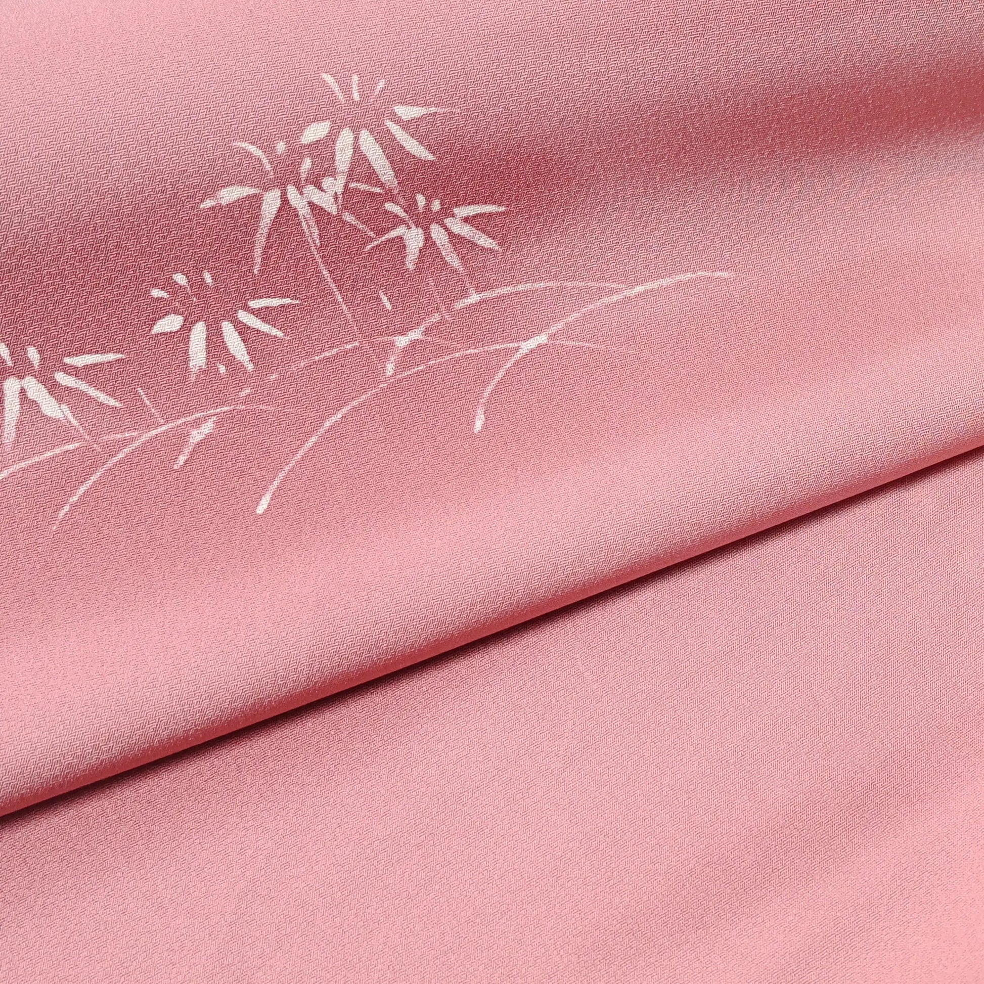 Close-up view of vintage Japanese silk kimono fabric in pale purple with a pink tone, featuring a bamboo motif.