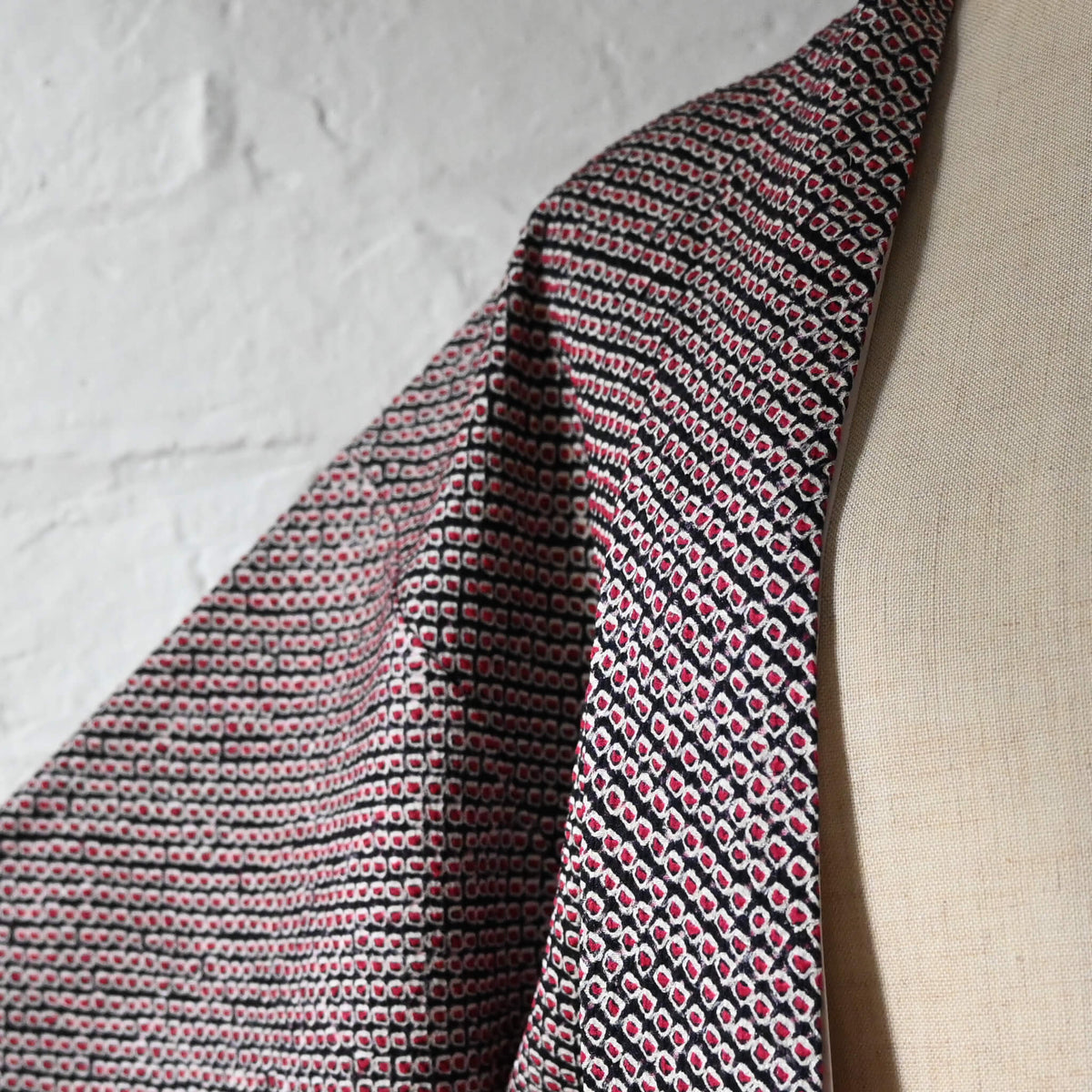 Close-up view of vintage women's silk textured all-over shibori haori in black and red-pink. 