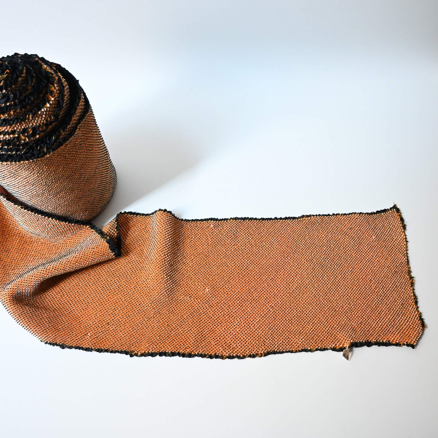 Full view of vintage silk shibori kimono fabric bolt in orange and black, unfinished, yunoshimae.