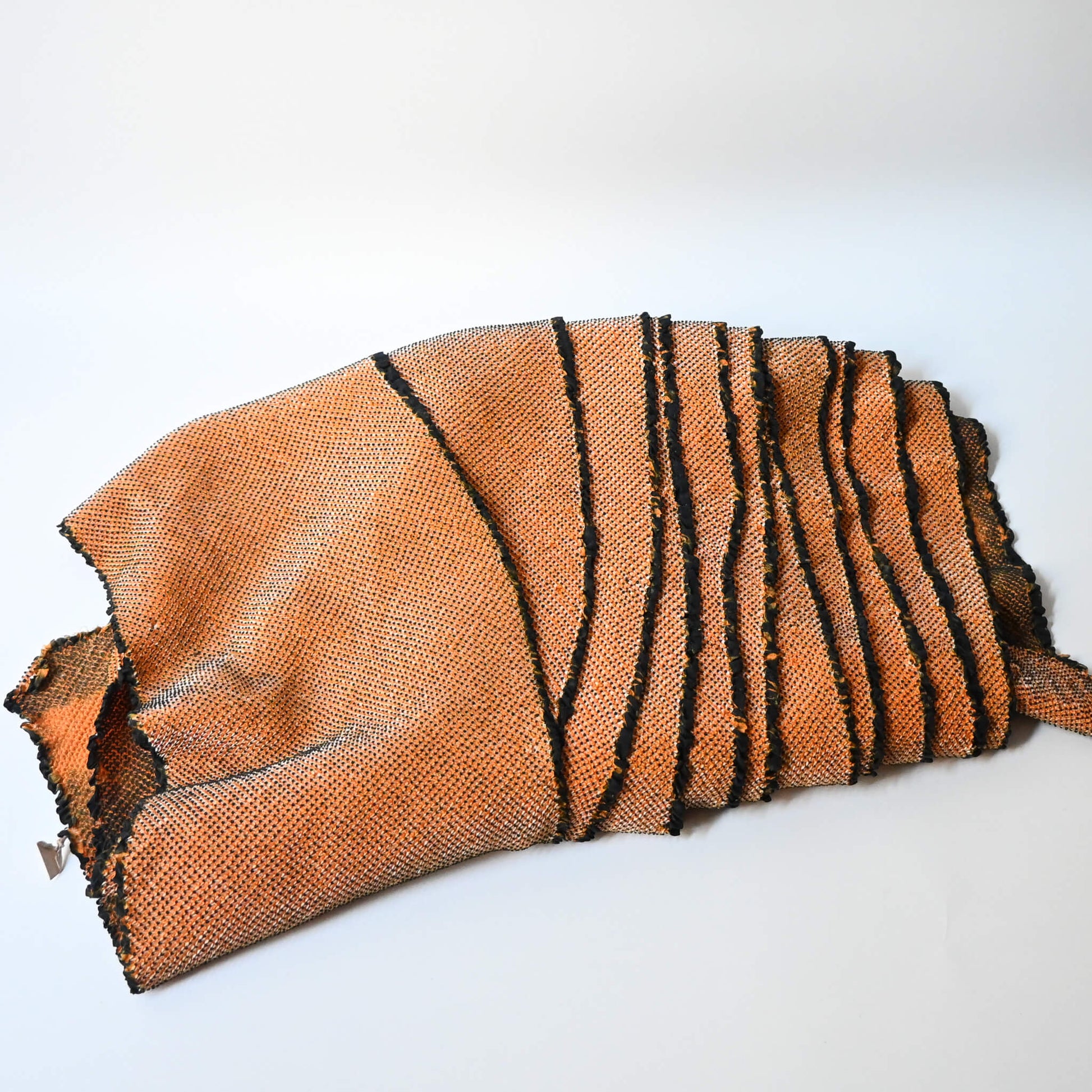 Full view of vintage silk shibori kimono fabric bolt in orange and black, unfinished, yunoshimae.