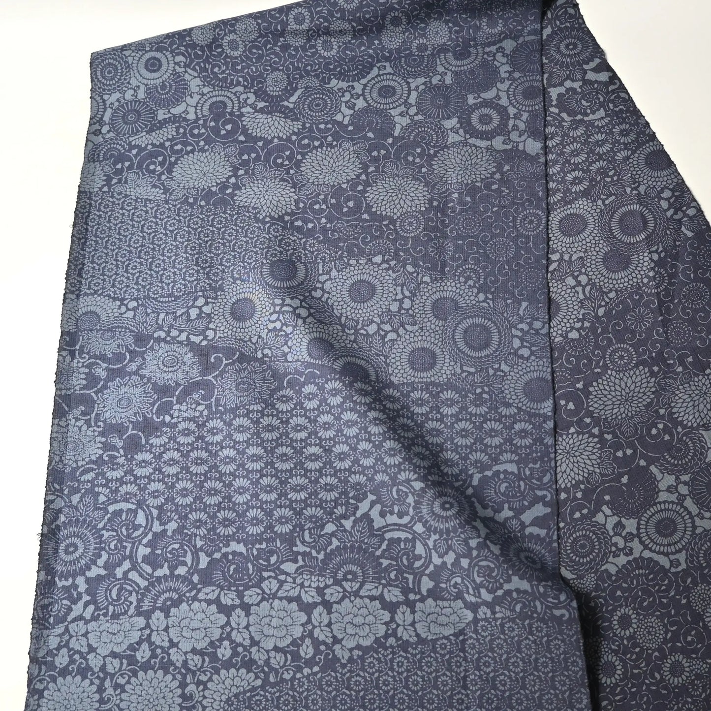 Vintage tsumugi silk kimono fabric with katazome floral arabesque pattern in soft indigo tones, double-sided.