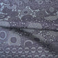 Detailed view of vintage tsumugi silk kimono fabric with katazome floral arabesque pattern in soft indigo tones.