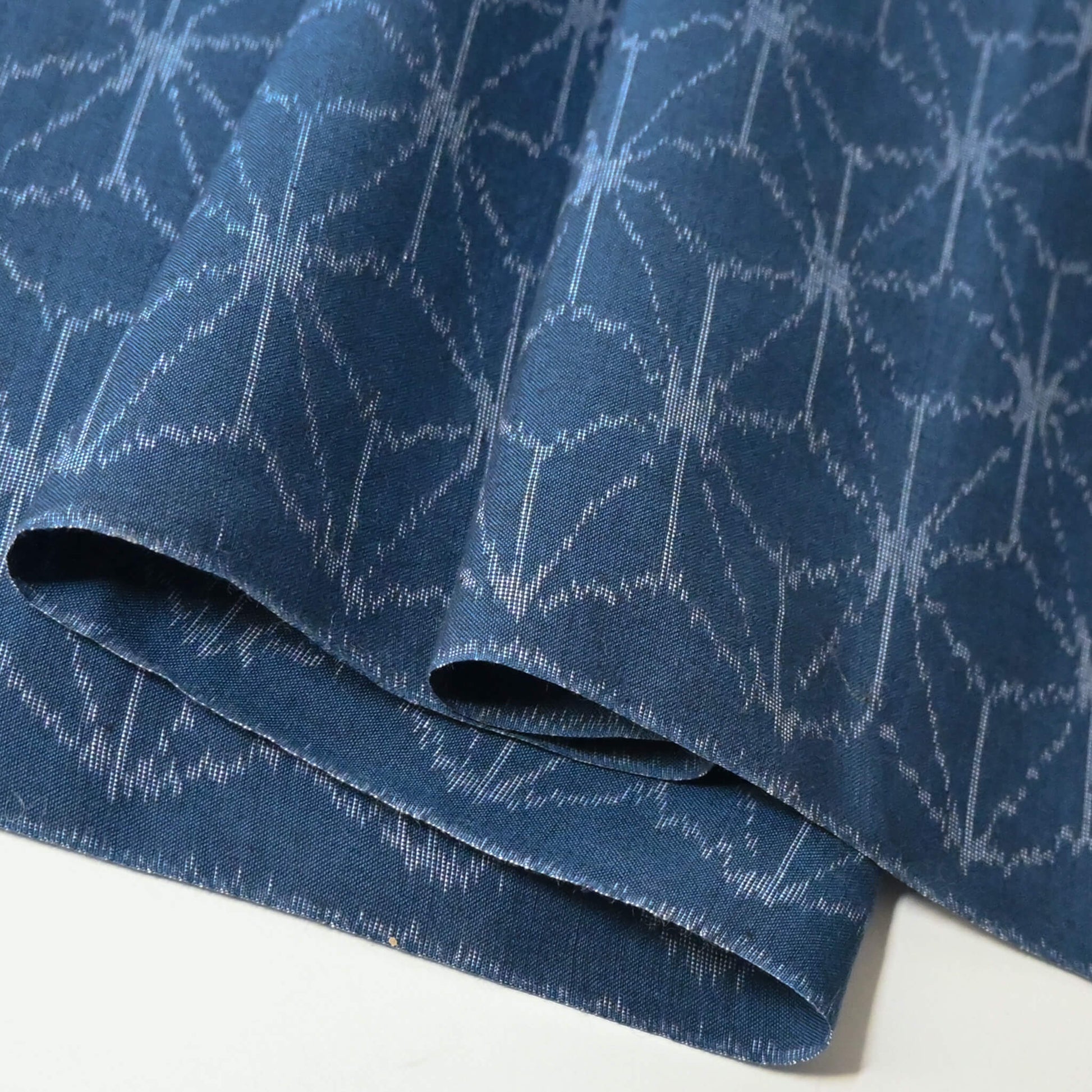 Close-up view of vintage soft blue cotton kimono fabric with Asanoha hemp leaf motif, sold by the metre.