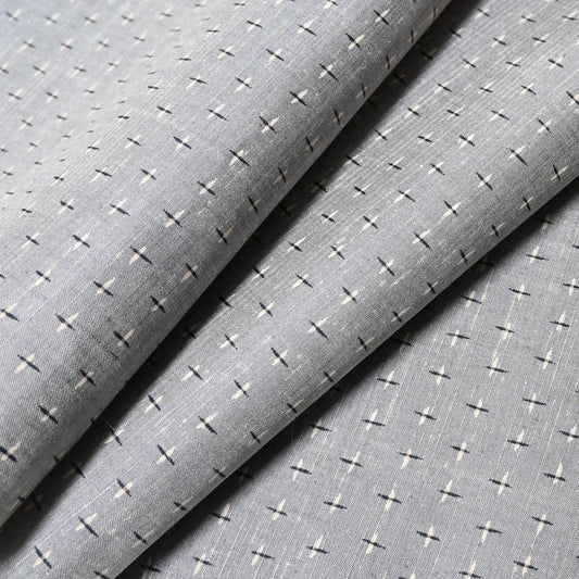 Close-up view of vintage soft blue-grey tsumugi kimono silk with small kasuri crosshatch pattern.