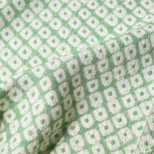 Detailed view of vintage soft lime green silk shibori kimono fabric piece.