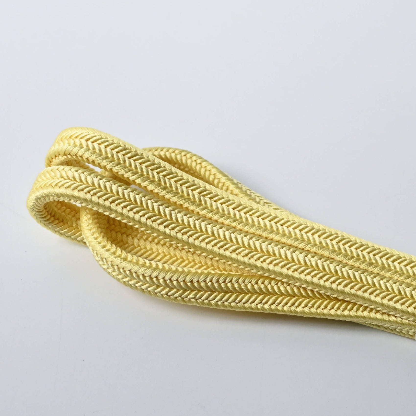 Close-up view of vintage soft yellow silk obijime kumihimo cord dyed with Kihada, unused condition.