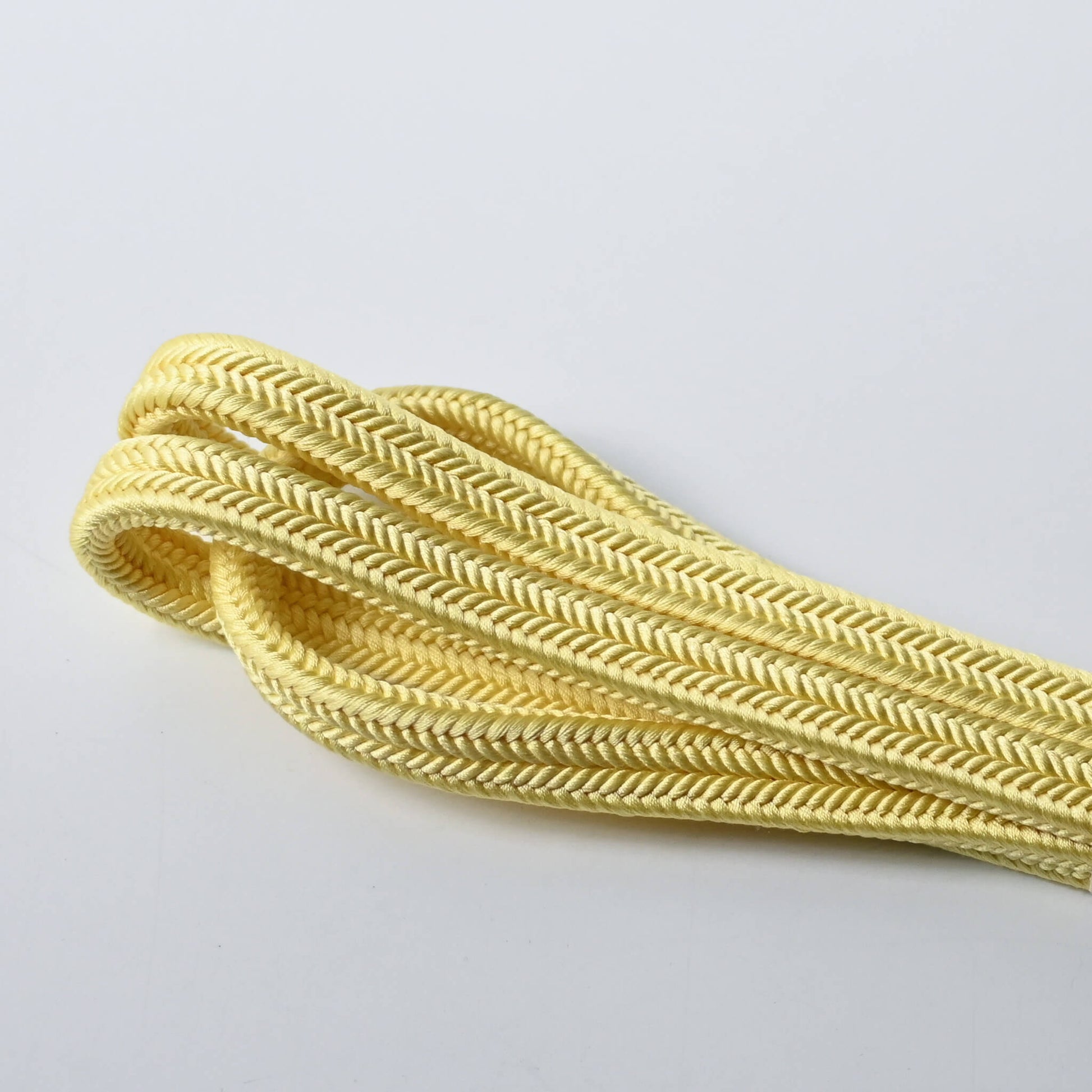 Close-up view of vintage soft yellow silk obijime kumihimo cord dyed with Kihada, unused condition.
