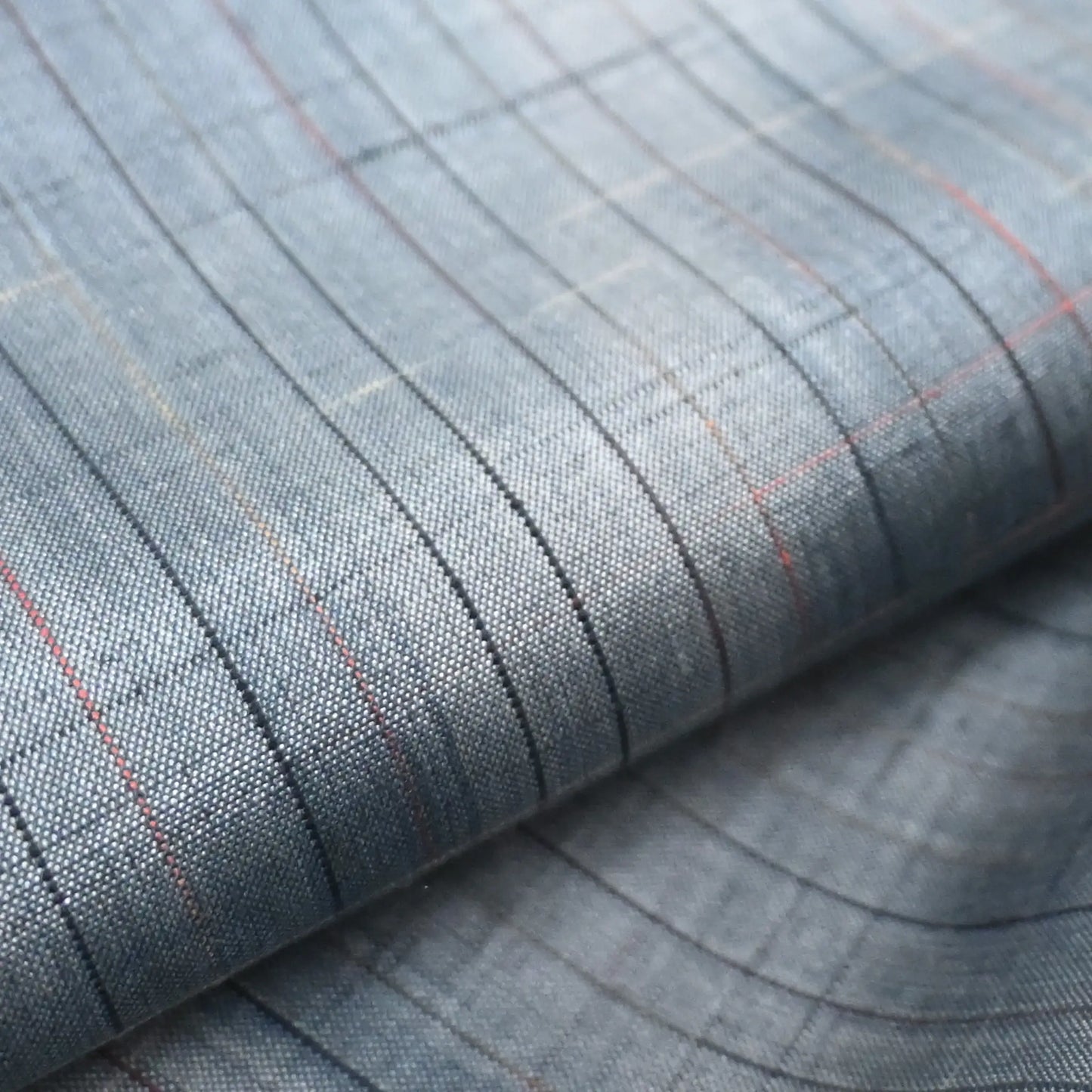 close-up of vintage Japanese tsumugi silk kimono fabric roll in stone blue with sheen.