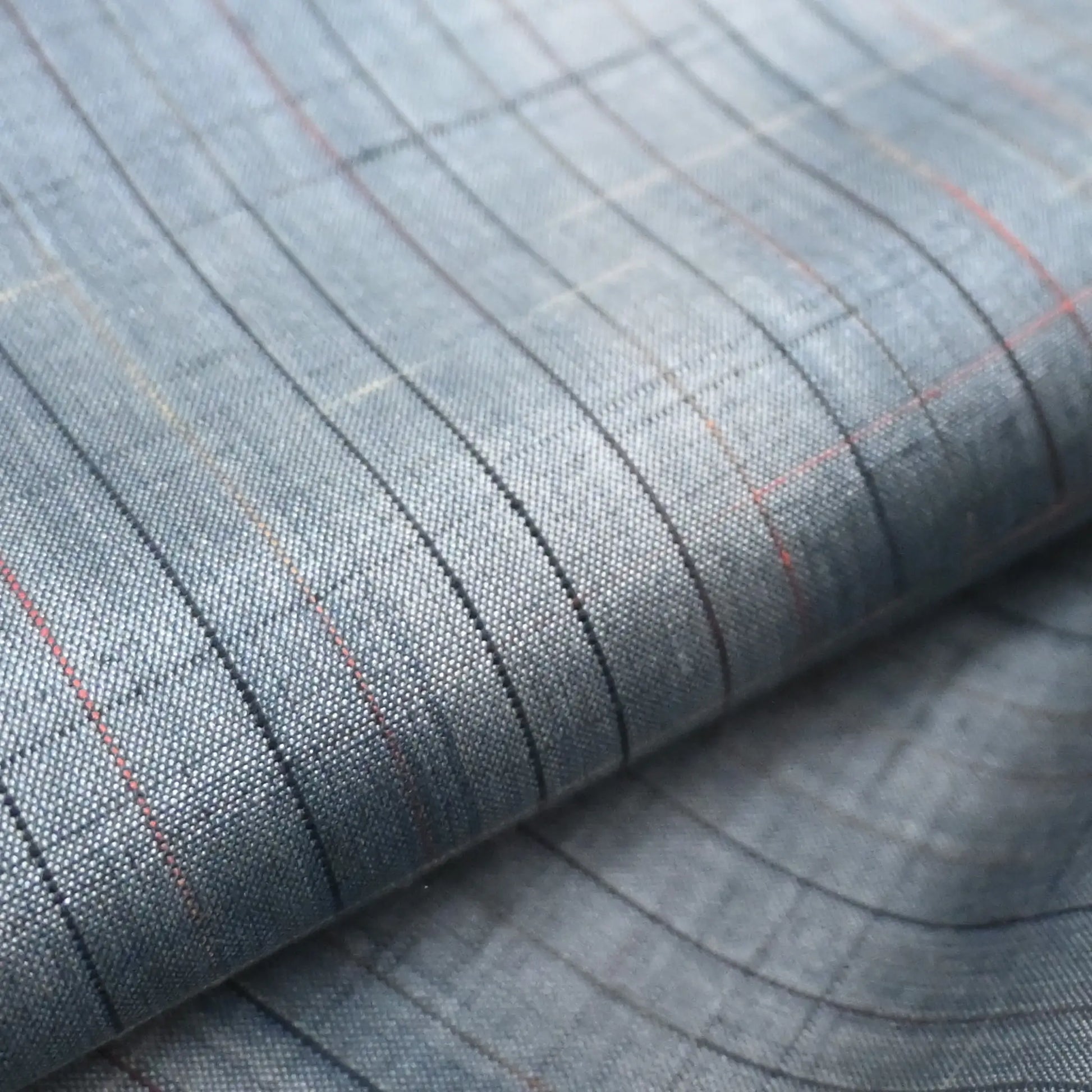 close-up of vintage Japanese tsumugi silk kimono fabric roll in stone blue with sheen.