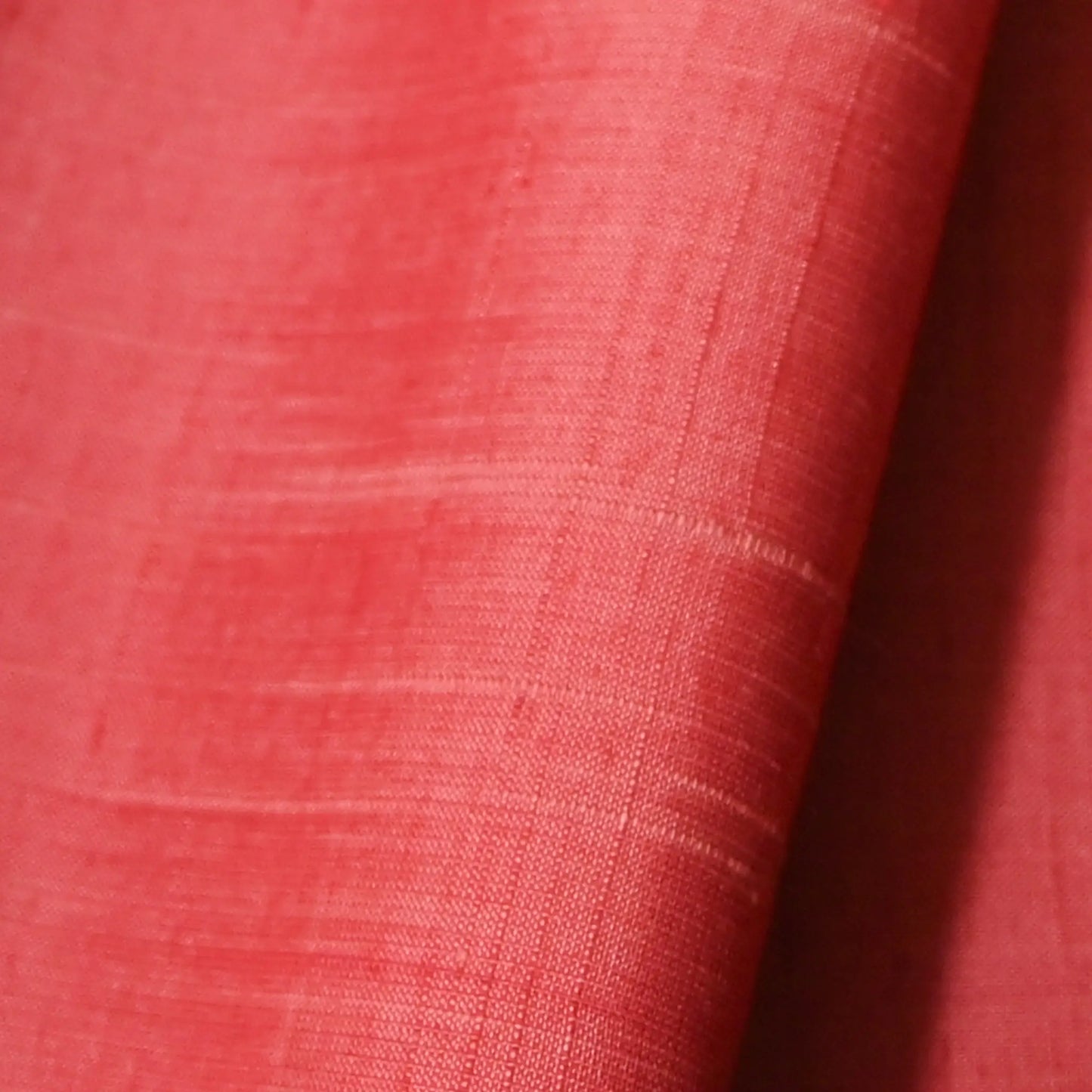 Detailed view of vintage strawberry red tsumugi silk kimono fabric sold by the metre.