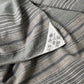Detailed view of vintage stripe cotton furoshiki in soft grey tone, with some mended patches with indigo cottons.