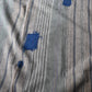 Detailed view of vintage stripe cotton furoshiki in soft grey tone, with some mended patches with indigo cottons.
