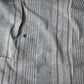 Detailed view of vintage stripe cotton furoshiki in soft grey tone, with some mended patches with indigo cottons.
