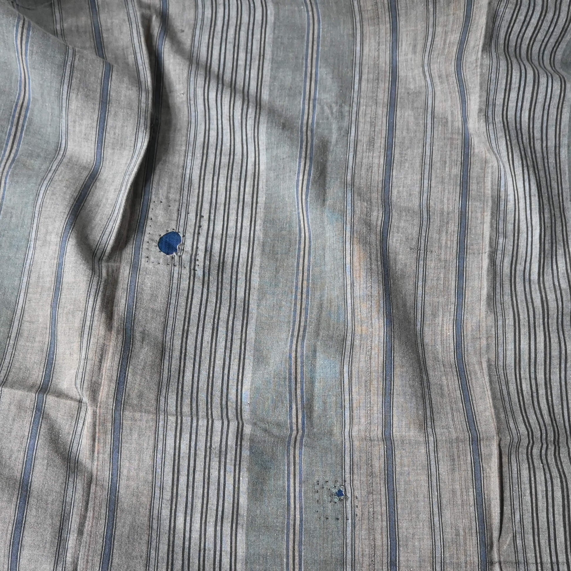 Detailed view of vintage stripe cotton furoshiki in soft grey tone, with some mended patches with indigo cottons.
