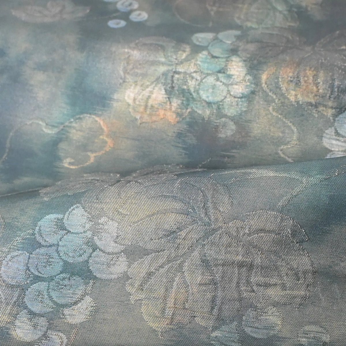 Close-up view of vintage muted teal blue silk Fukure-ori obi with grape vine motif.