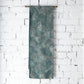 Hanging view of vintage muted teal blue silk Fukure-ori obi with grape vine motif.