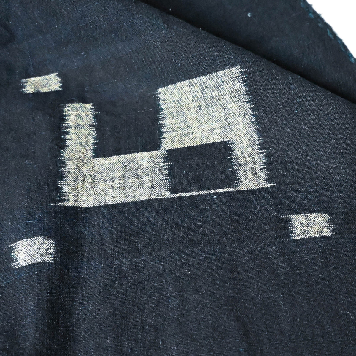 Close-up view of vintage Japanese three-panel indigo kasuri cotton furoshiki with simple and understated design.