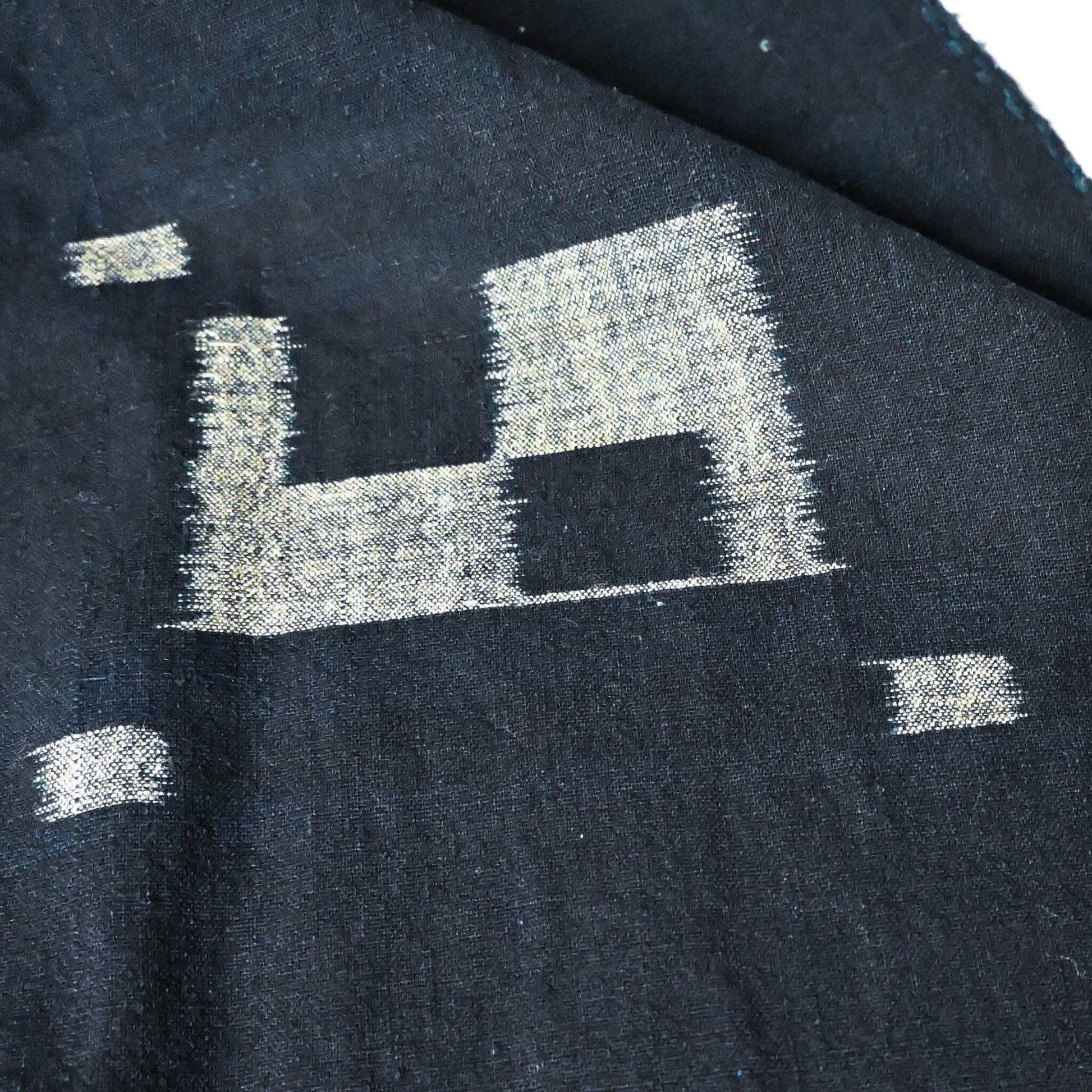 Close-up view of vintage Japanese three-panel indigo kasuri cotton furoshiki with simple and understated design.