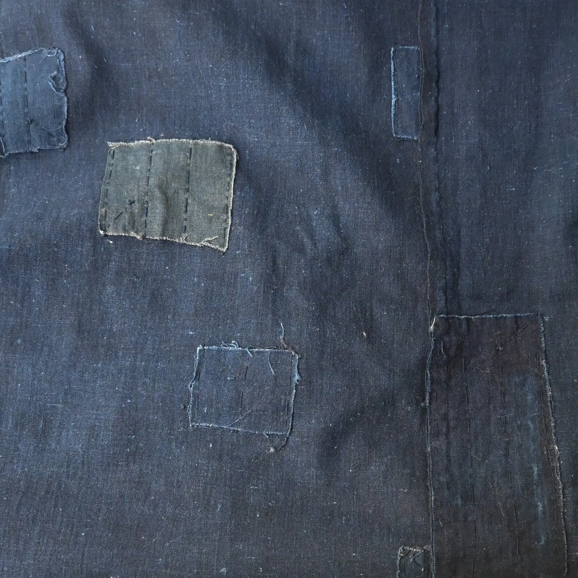 Detailed view of vintage Japanese three-panel plain indigo cotton futon cover with patches from the mid-20th century.