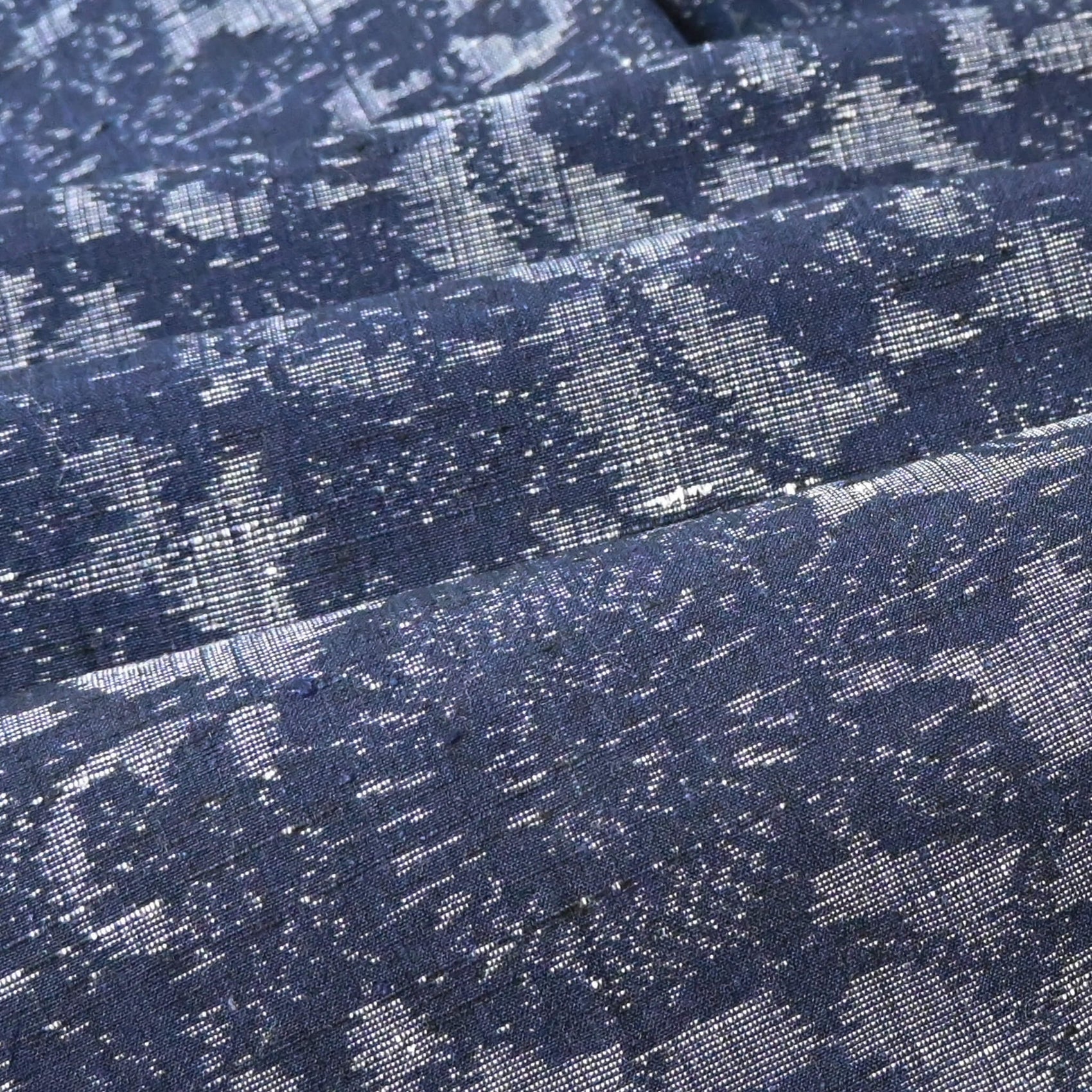 Close-up view of Vintage Japanese tsumugi kimono silk fabric piece with a classic chrysanthemum arabesque pattern.