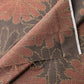 Detailed view of vintage brown tusmugi kimono silk fabric piece with chrysanthemum motif.