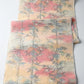 Full view of vintage tsumugi silk kimono fabric piece in soft yellow and pink with bamboo motif.
