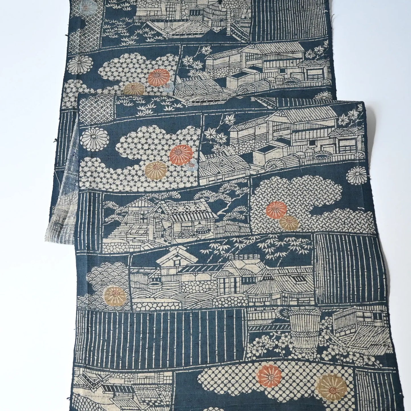 Vintage muted blue tsumugi silk kimono fabric piece with houses and chrysanthemum accents.