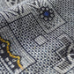 Close-up view of vintage tsumugi silk kimono fabric with intricate woven geometric pattern.