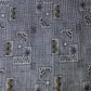 Detailed view of vintage tsumugi silk kimono fabric with intricate woven geometric pattern.