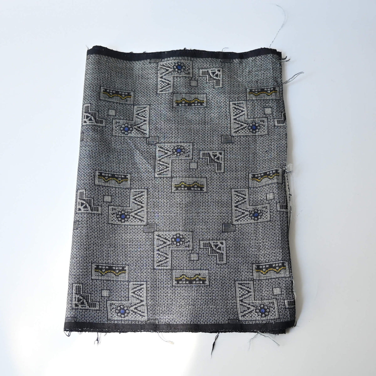 Vintage tsumugi silk kimono fabric with intricate woven geometric pattern.