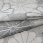Detailed view of vintage Japanese tsumugi silk kimono fabric with large round chrysanthemum pattern  in grey.