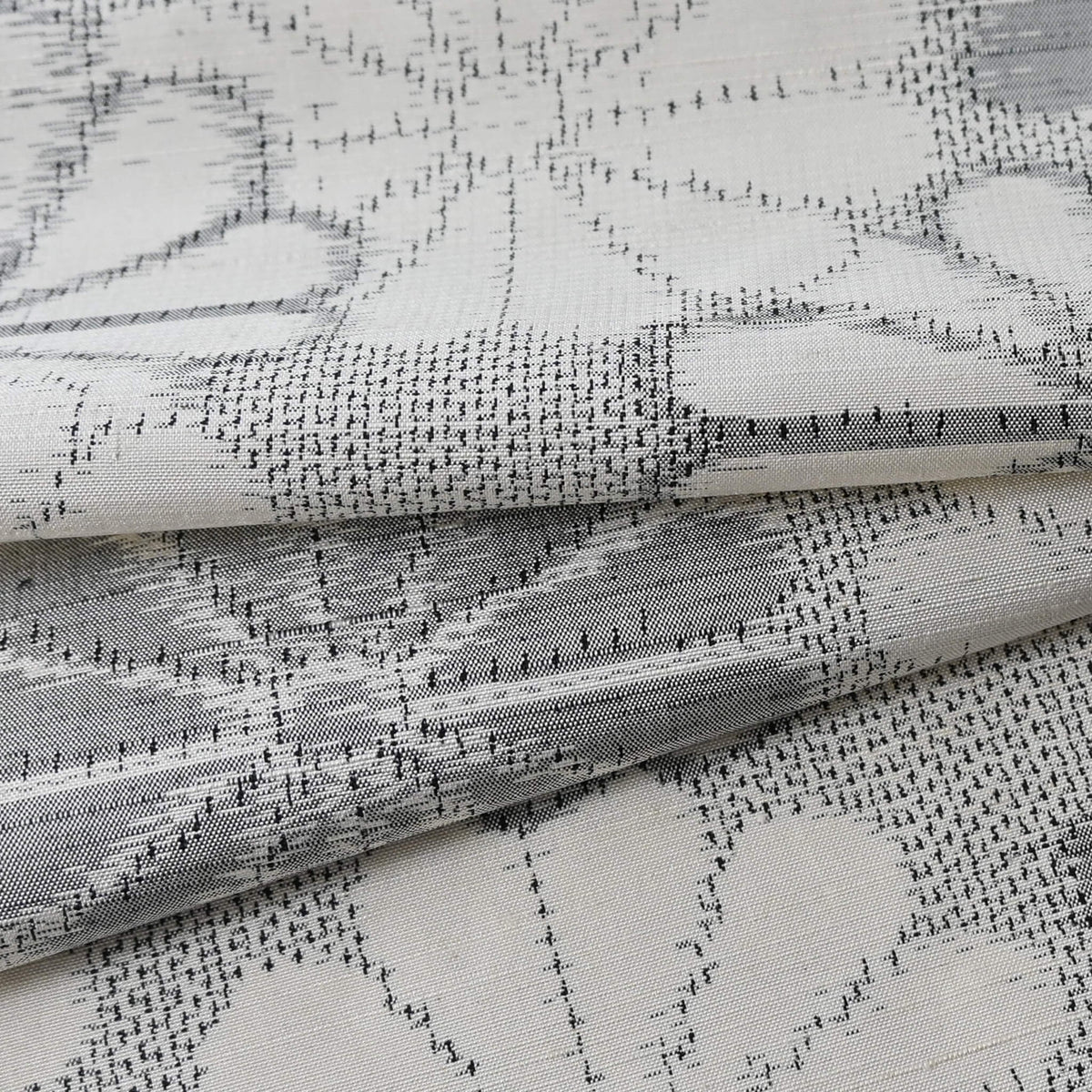 Detailed view of vintage Japanese tsumugi silk kimono fabric with large round chrysanthemum pattern  in grey.