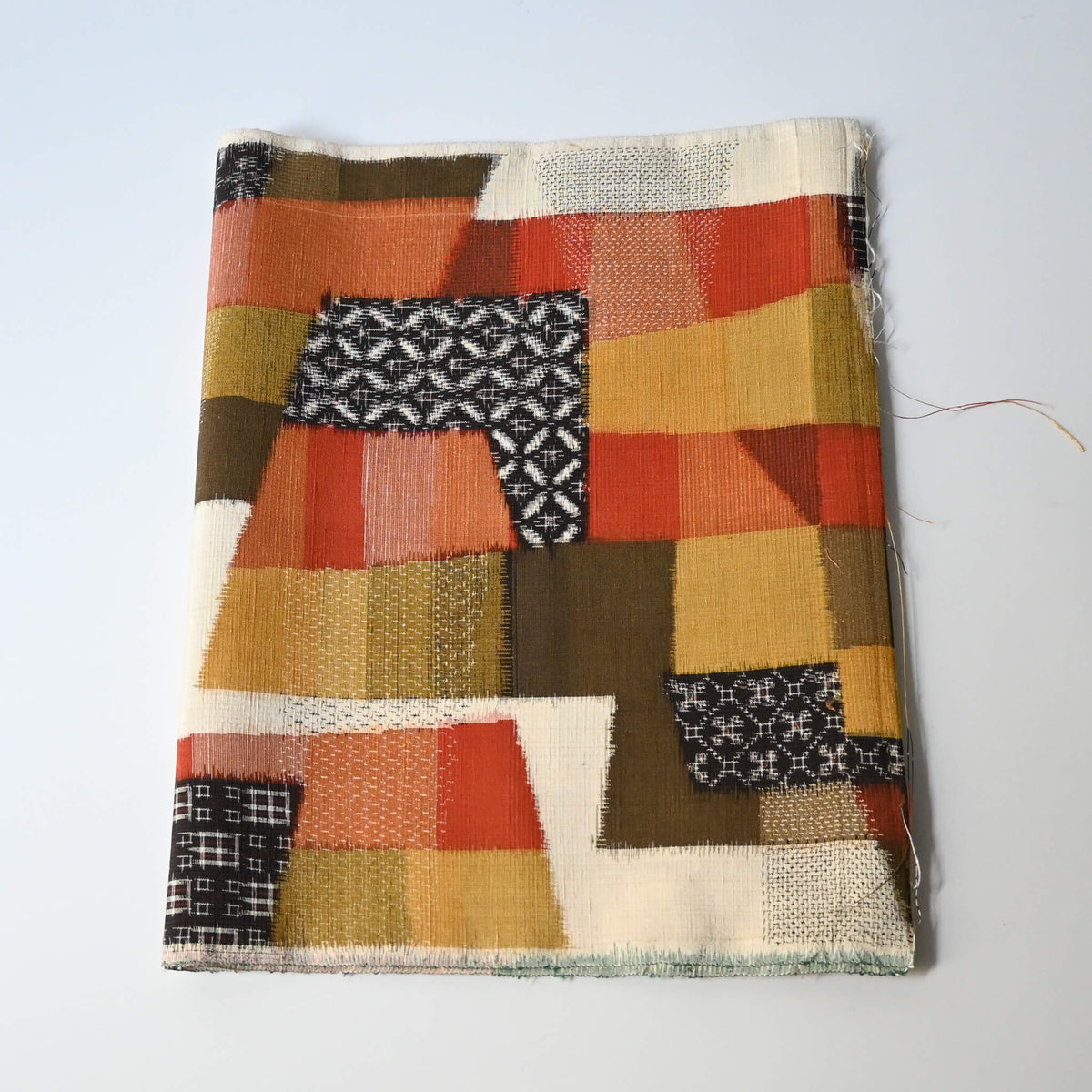 Vintage textured tsumugi silk kimono fabric with  an abstract geometric design in warm shades.