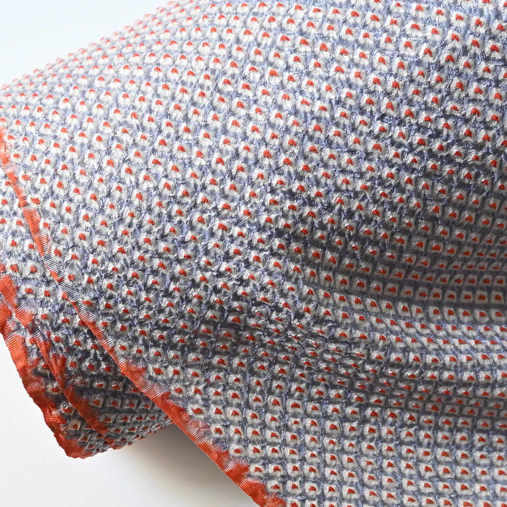 Close-up view of vintage silk shibori kimono fabric dyed with a misty blue-grey base and soft orange accents.