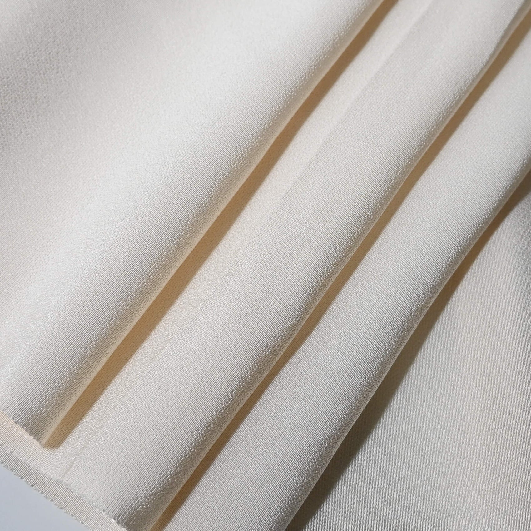Close-up view of vintage Japanese undyed plain silk kimono fabric in cream, ivory tone.