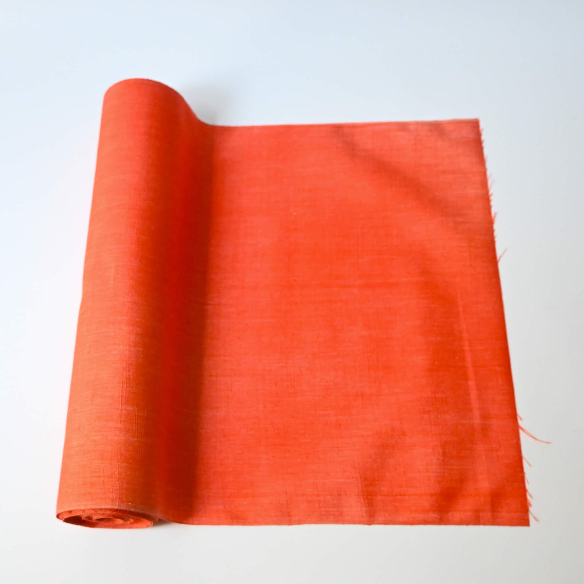 Vintage tsumugi silk kimono fabric in vibrant vermillion orange sold by the metre.