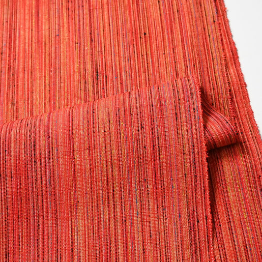 Detailed view of vintage vivid orange stripe tsumugi silk kimono fabric.