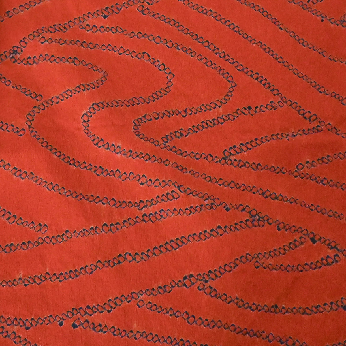Close-up view of vintage women’s burnt orange silk shibori haori with organic line motifs in deep blue.