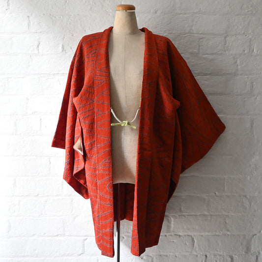 Vintage women’s burnt orange silk shibori haori with organic line motifs in deep blue.
