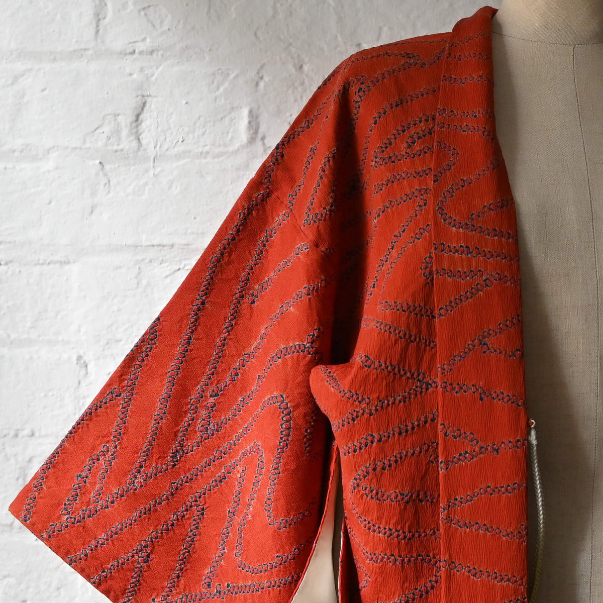Vintage women’s burnt orange silk shibori haori with organic line motifs in deep blue.