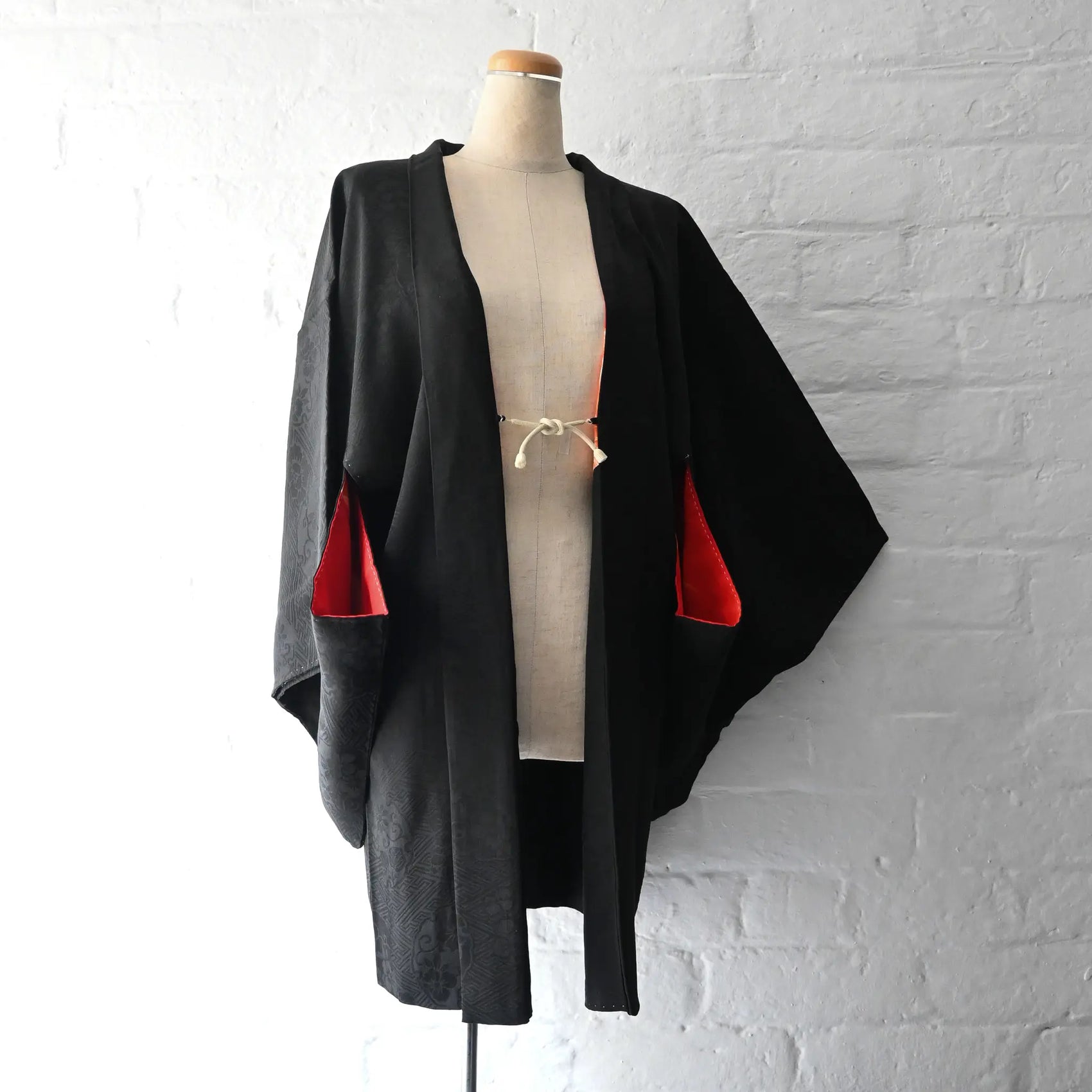 Vintage women's black rinzu silk semi-formal haori with red silk lining.